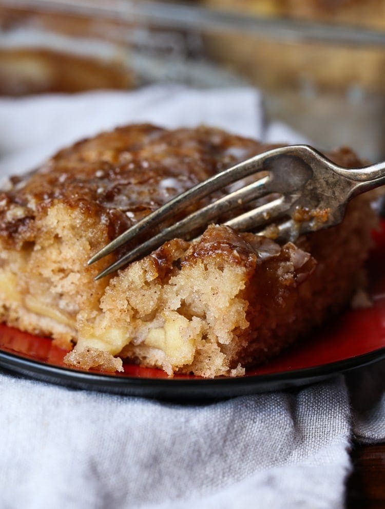 Fork cutting into apple fritter cake