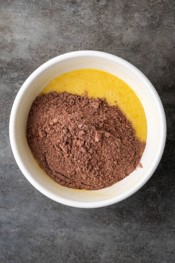 Dry ingredients added to wet banana bread brownie batter in a mixing bowl.