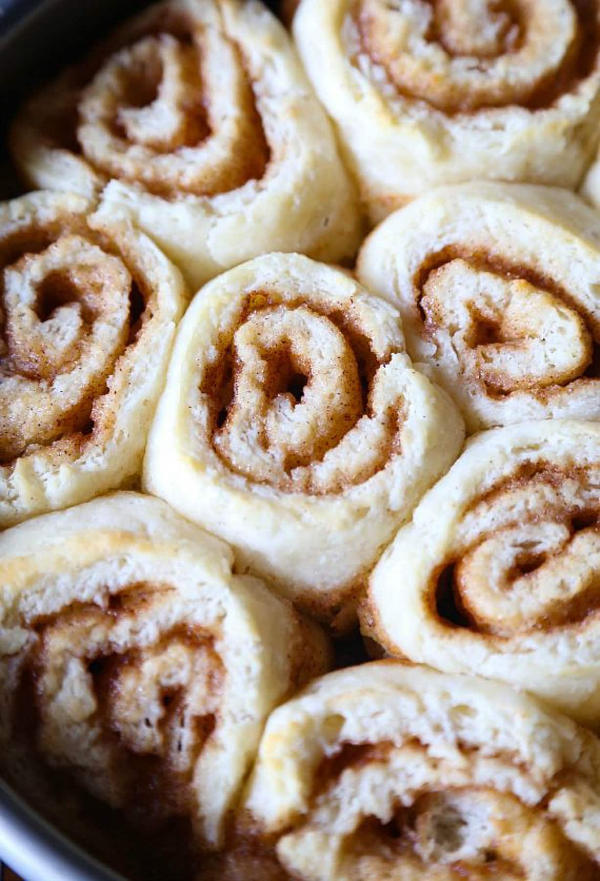 Golden brown cinnamon roll biscuits in a 9-inch pan