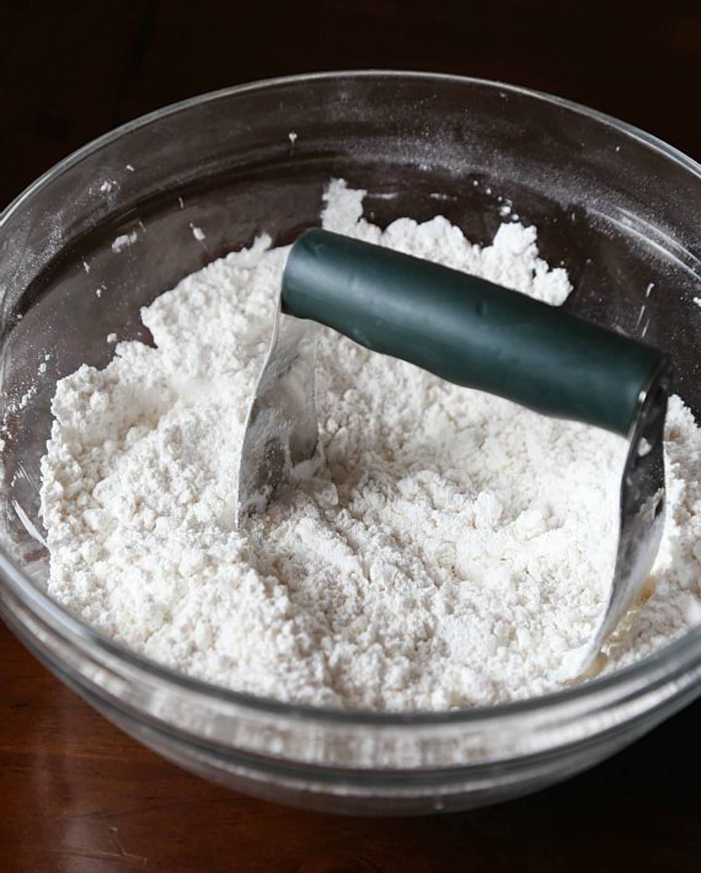 A pastry cutter in a bowl with butter and flour cut together