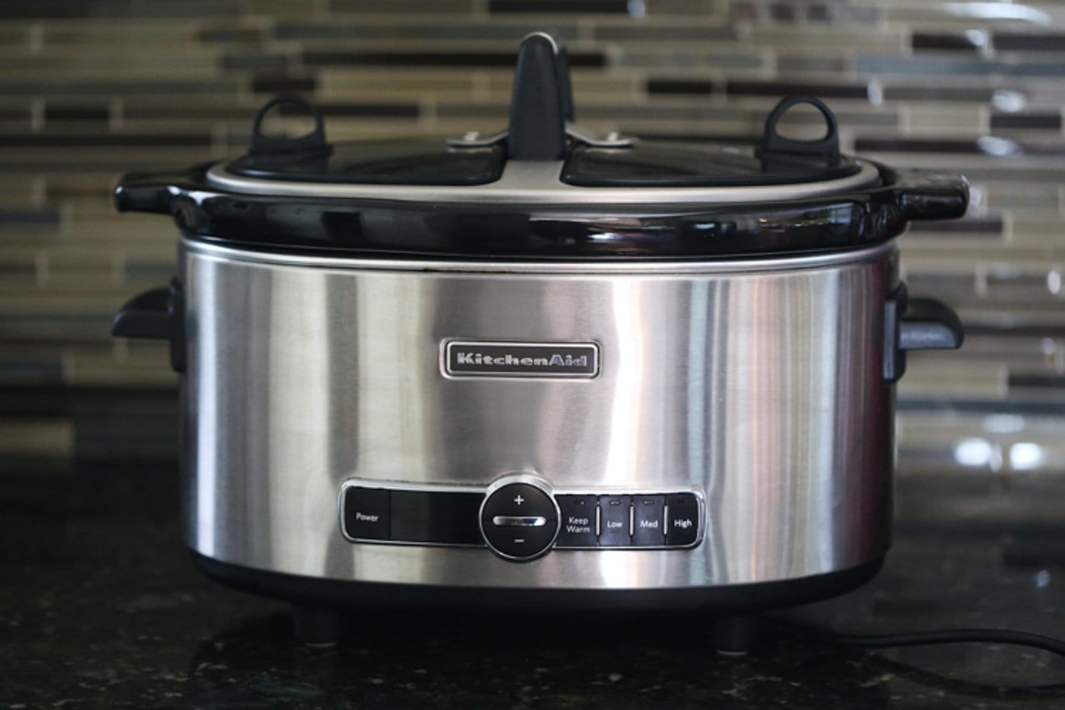 A silver slow cooker on a kitchen counter