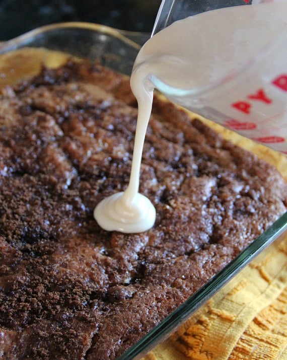 Glaze being poured over baked apple fritter cake