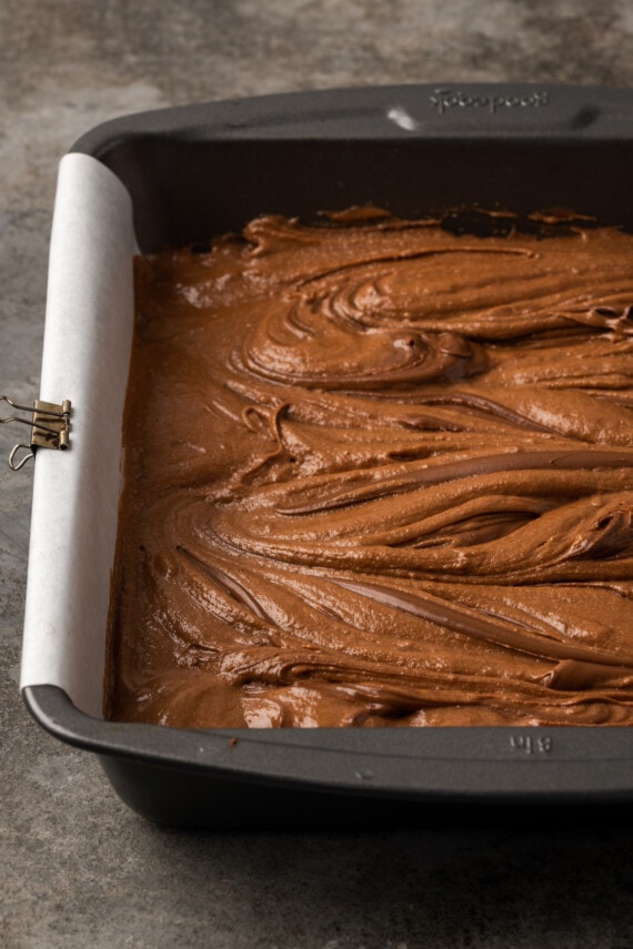 Nutella swirled brownie batter in a baking pan.