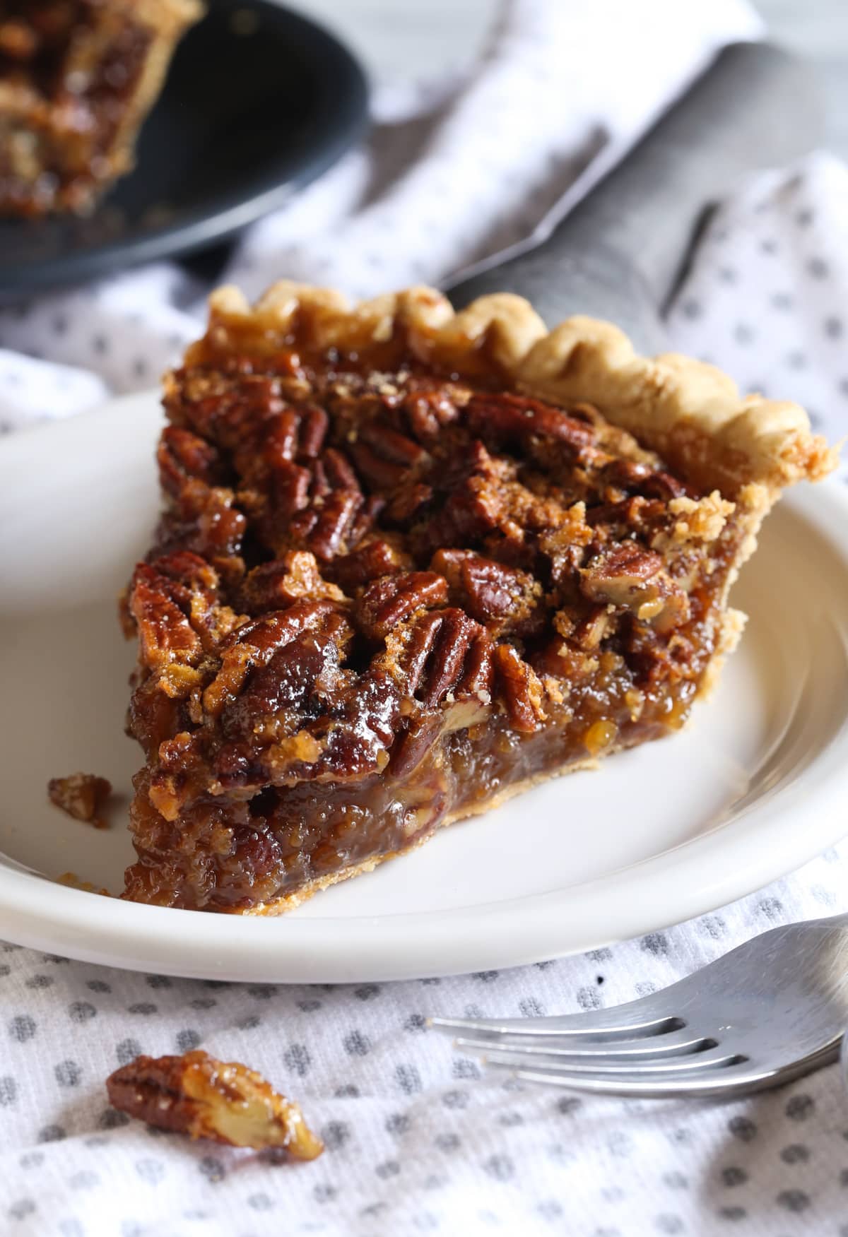 A slice of pecan pie on a white plate
