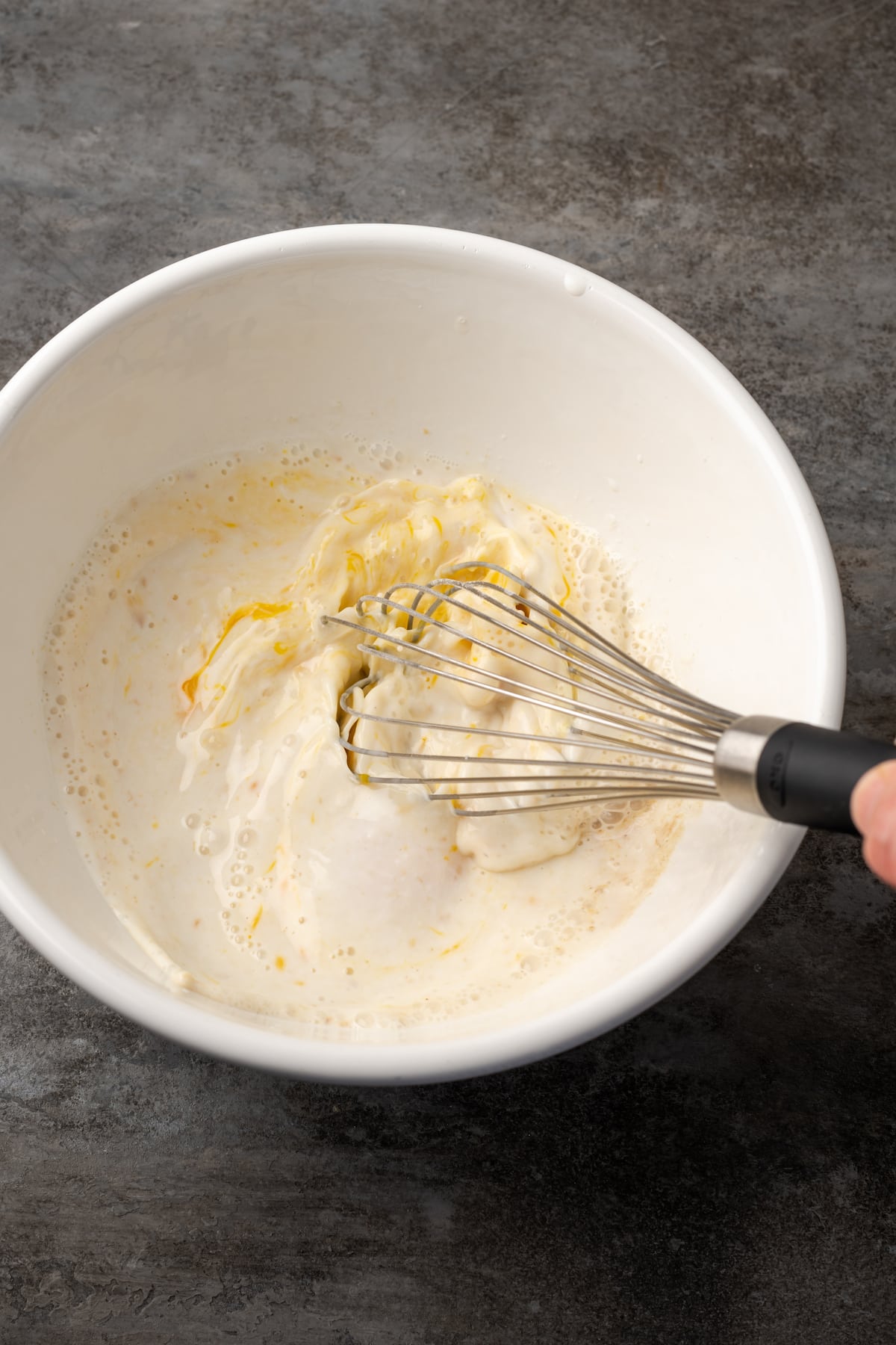 Wet ingredients are whisked together in a mixing bowl.